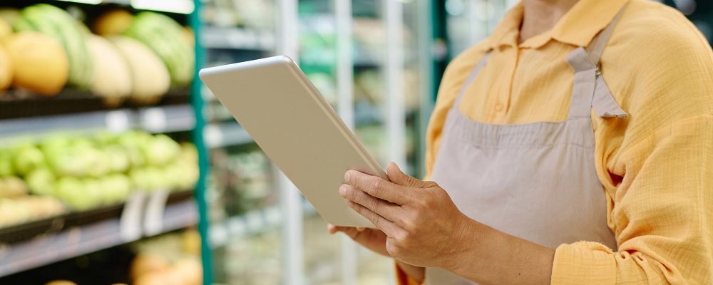 Manager of supermarket using tablet pc to control goods online